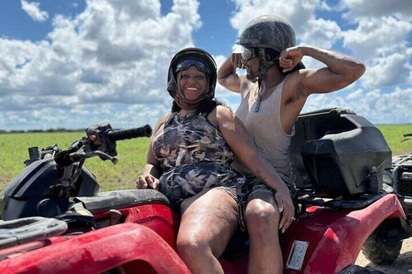 Dos personas sobre un cuatrimoto rojo en un campo. 3