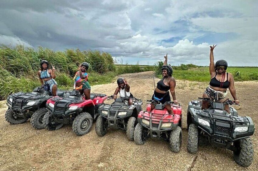 Cuatro personas en vehículos todo terreno en un entorno rural, con un camino de tierra y vegetación. 2