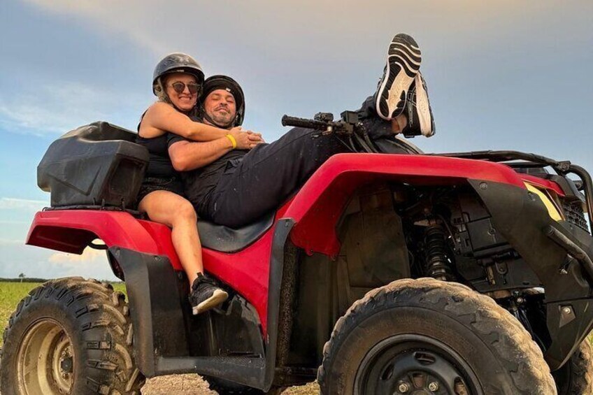 Dos personas sobre un cuatrimoto rojo en un campo. 4