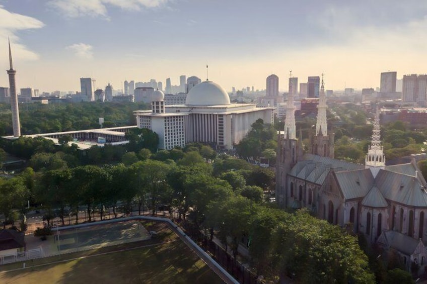 A cityscape with a prominent mosque, a large dome, and a church with multiple spires. 3
