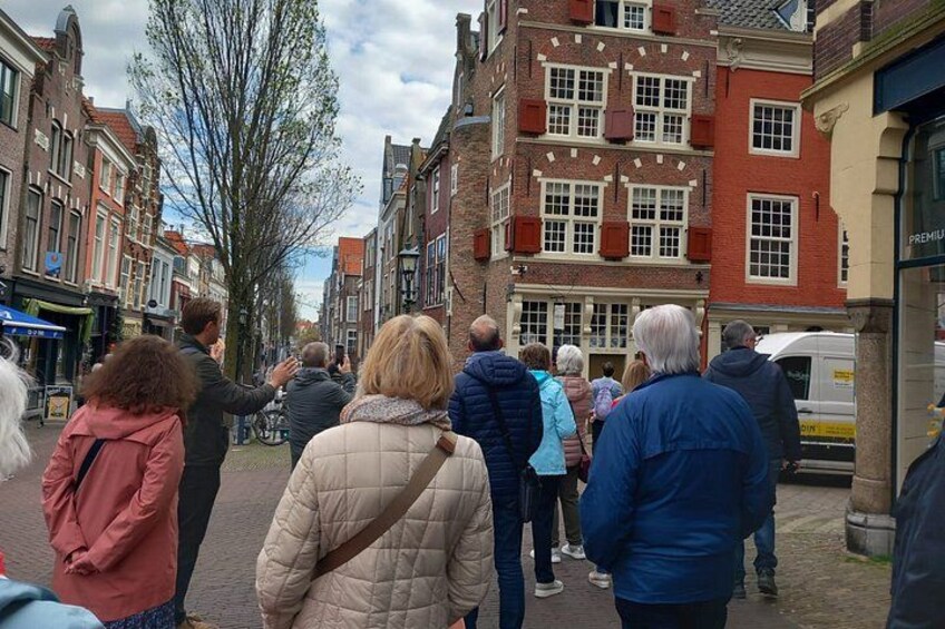 A group of people walking on a cobblestone street lined with historic buildings. 2