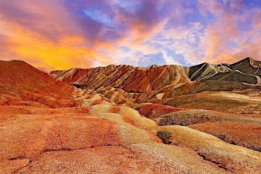 A desert landscape with layered rock formations and a sunset sky. 3