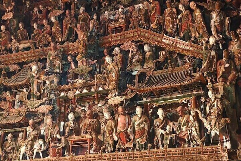 A detailed mural with figures in traditional attire, ornate architecture, and a tiered structure. 5