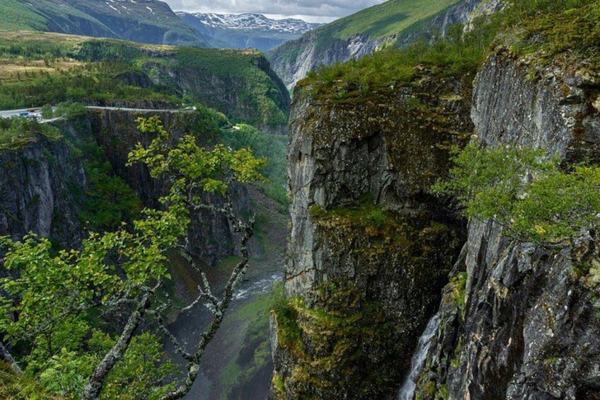 A canyon with a river, steep cliffs, and a bridge. 5