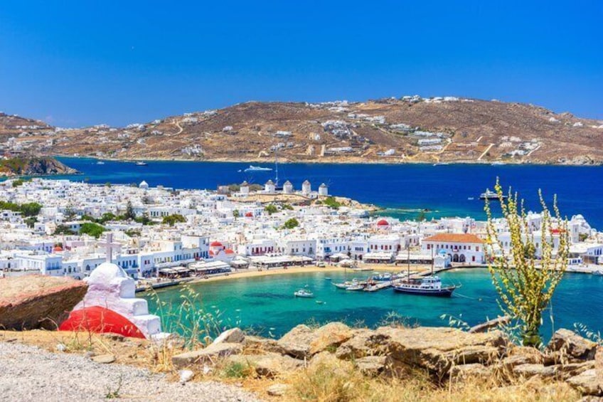 A coastal town with white buildings, a clear blue sea, and rocky terrain. 5