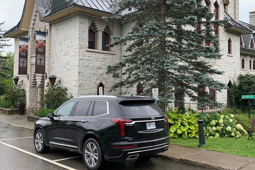A black SUV parked in front of a stone building with a sign that reads 'Porter.' 1