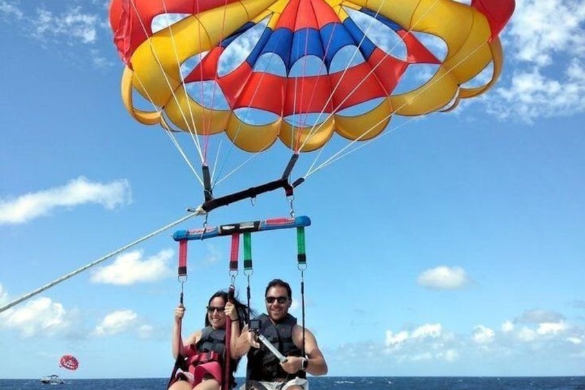 A person parasailing with a colorful parachute over the ocean. 2
