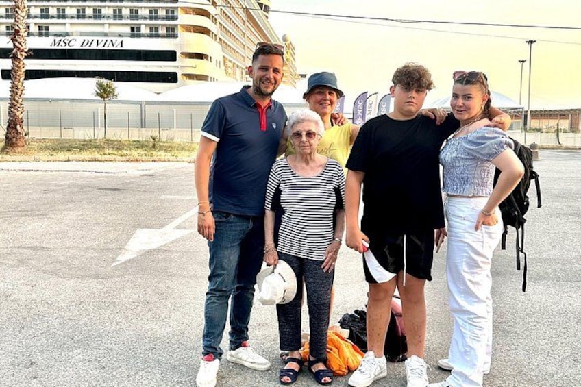 A group of people standing in front of a cruise ship named MSC DIVINA. 2