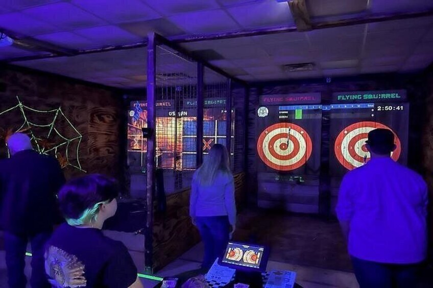 A room with dartboards and a digital scoreboard. 3
