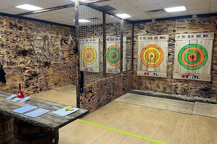 Un campo de tiro cubierto con paredes de madera, blancos y una estación de tiro. 3