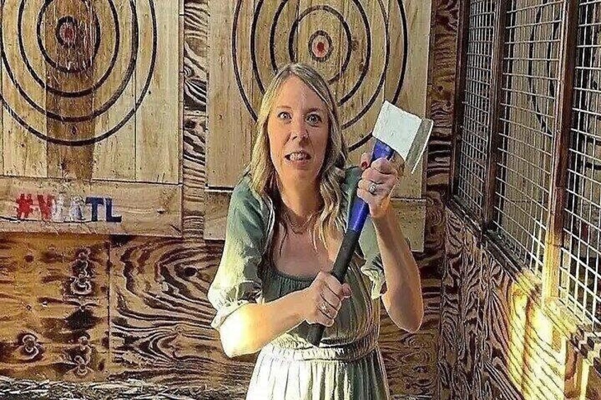 A person holding an axe in front of a target with concentric circles. 2