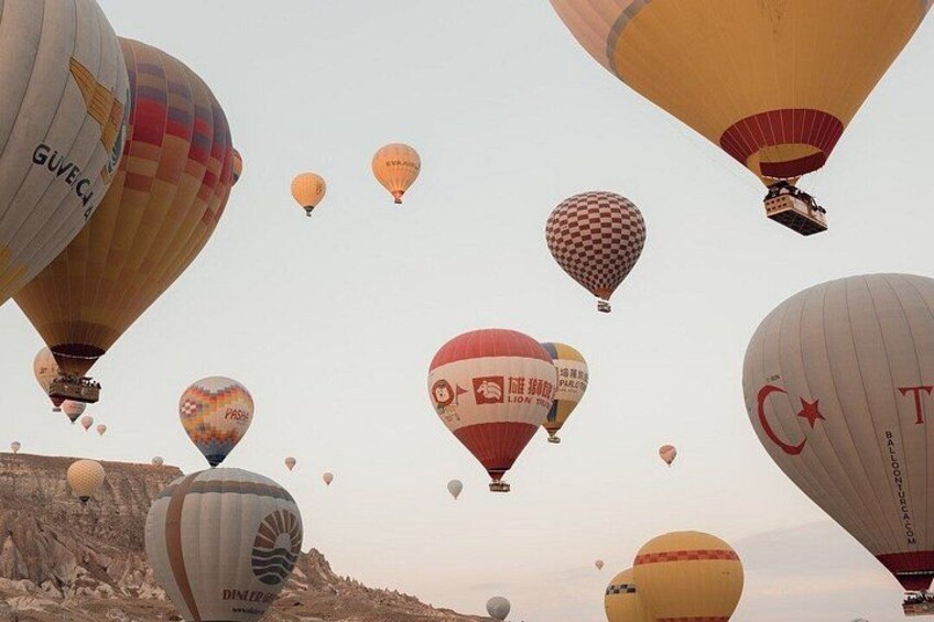 A variety of hot air balloons in the sky over a rocky landscape. 4