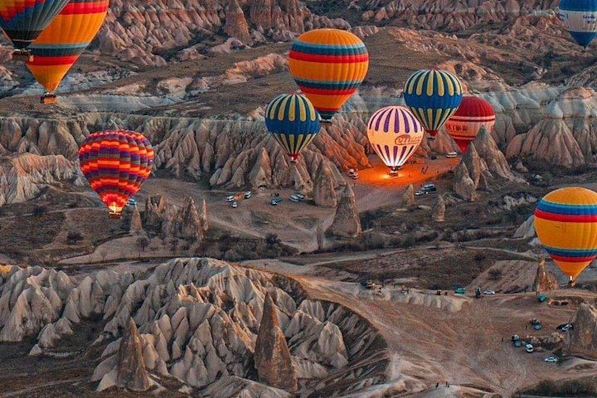 A landscape with multiple colorful hot air balloons. 5