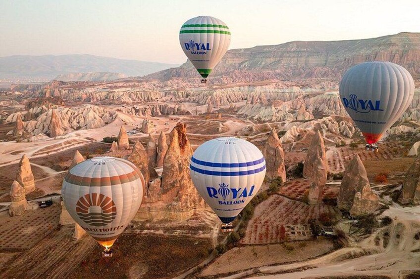 Hot air balloons over a rugged landscape with distinctive rock formations. 2