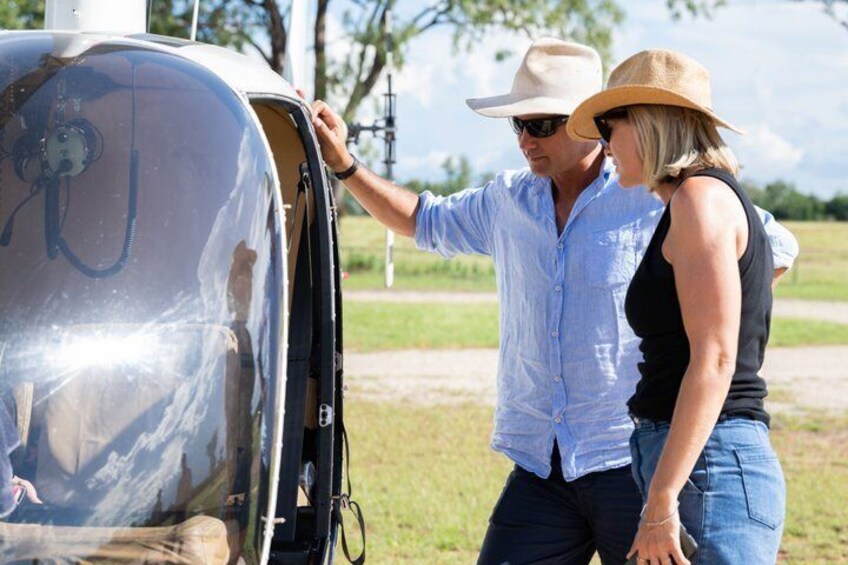 Two people inspecting a large, metallic vehicle with a transparent side. 2