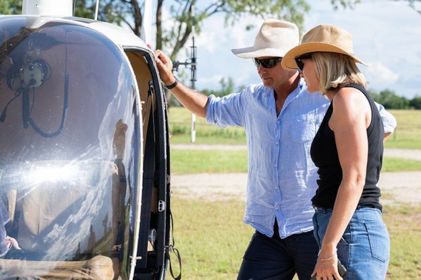 A man and a woman standing next to a vehicle with an open door. 2