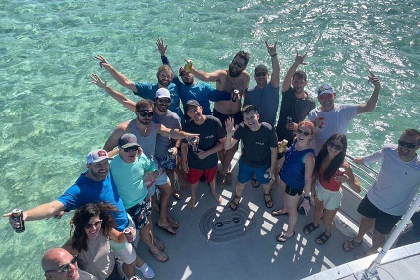 Eine Gruppe von Menschen auf einem Boot in klarem Wasser. 2
