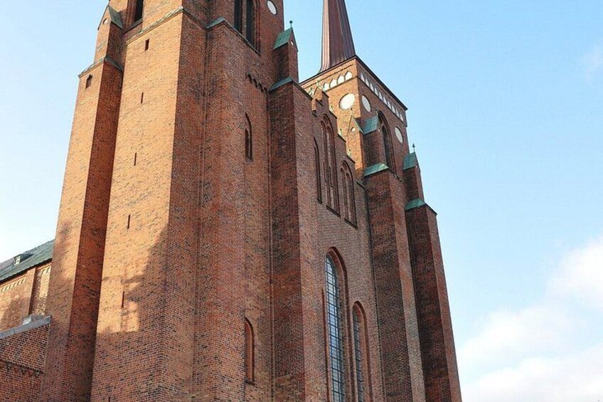 A large brick church with a tall spire and arched windows. 2