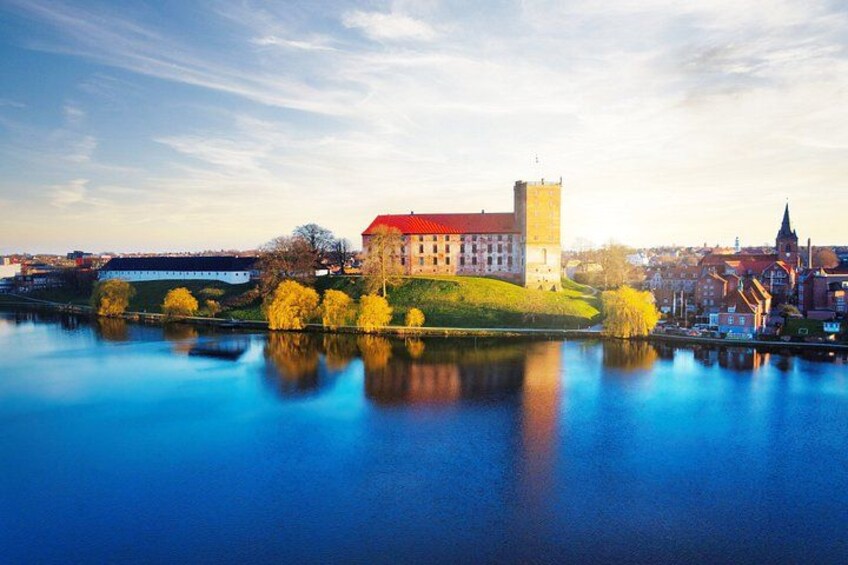 A castle on a hill with a river in the foreground. 1