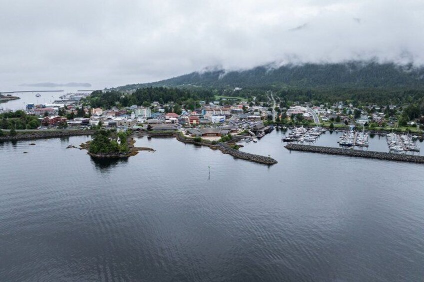 A coastal town with a marina, a small island, and a mountain range in the background. 3