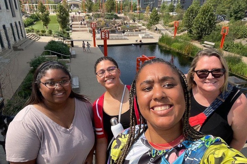 Een groep mensen maakt een selfie met uitzicht op een waterpartij en stadslandschap. 4