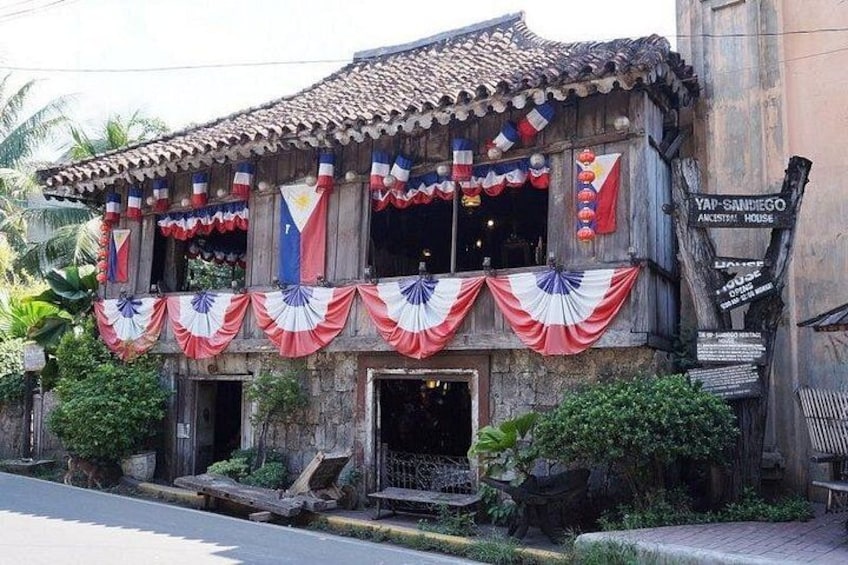 Un edificio con tejado de tejas, decorado con banderas y cortinas. 3