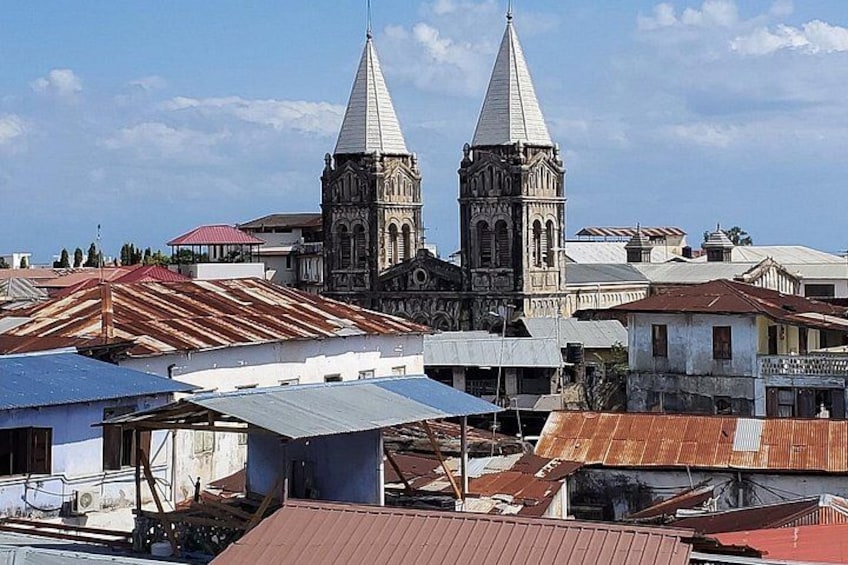 Una iglesia histórica con dos torres, rodeada de edificios residenciales con tejados de varios colores. 1