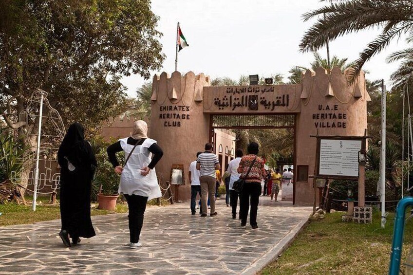 The entrance to the Emirates Heritage Village with a traditional archway and a flag. 5