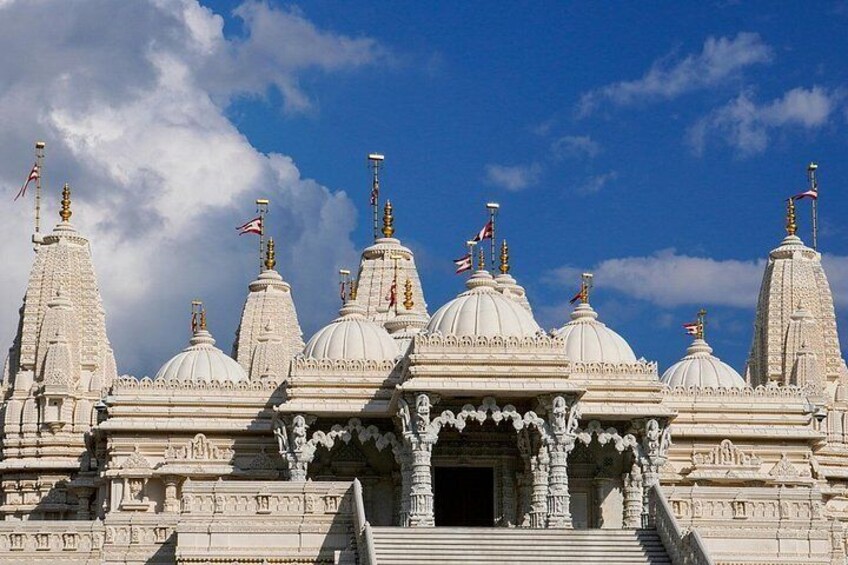 A white temple with multiple domes and intricate carvings. 4