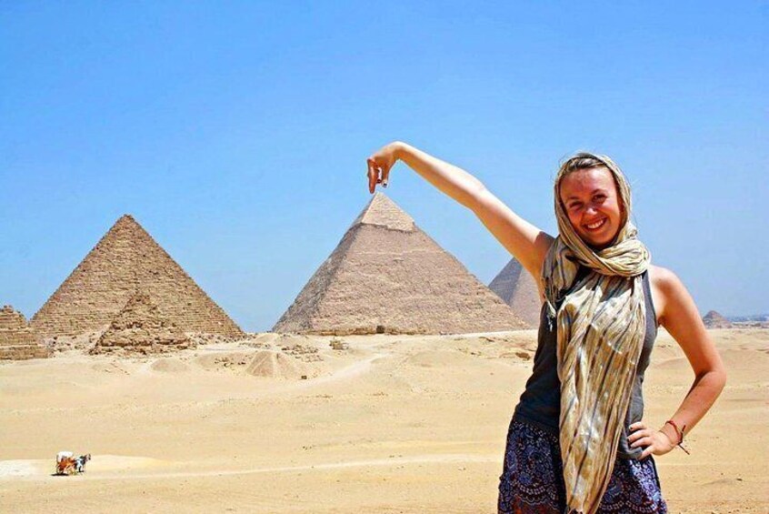A person standing in front of the pyramids with a clear blue sky. 4