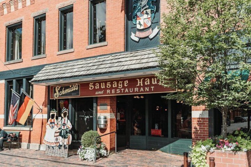 A brick building with a sign reading "Sausage Haus and Restaurant." 1
