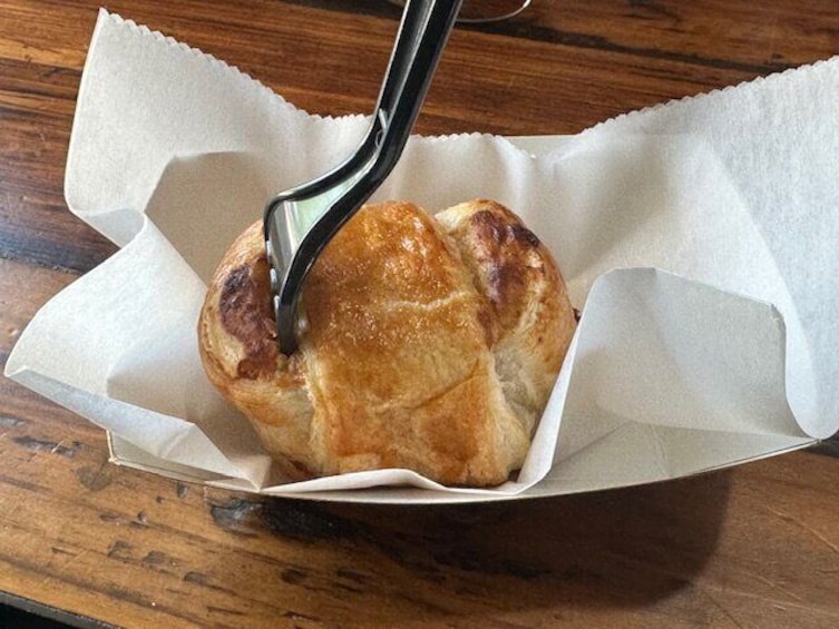 A pastry in a paper container with a fork. 5