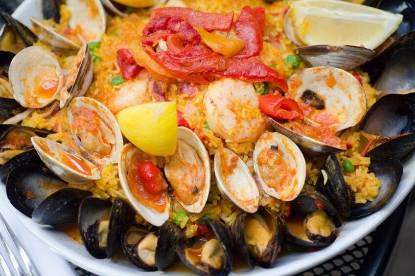 En paella med skaldjur, musslor, räkor och citronklyftor. 2