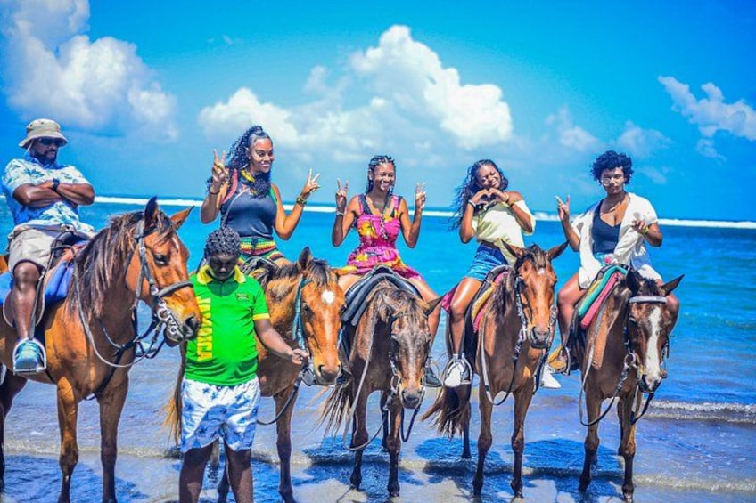 Eine Gruppe von Menschen reitet am Strand. 2
