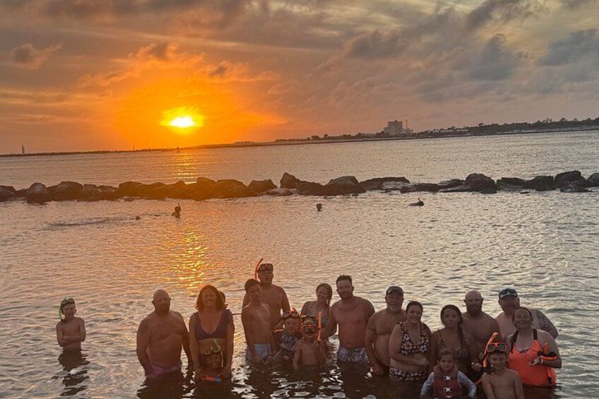Un gruppo di persone in piedi nell'acqua bassa al tramonto. 1