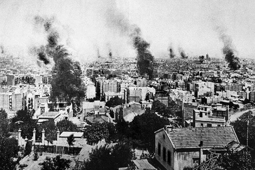 A cityscape with multiple buildings and smoke rising from chimneys. 2