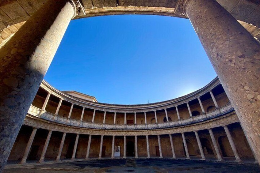 A circular building with columns and a clear blue sky above. 2