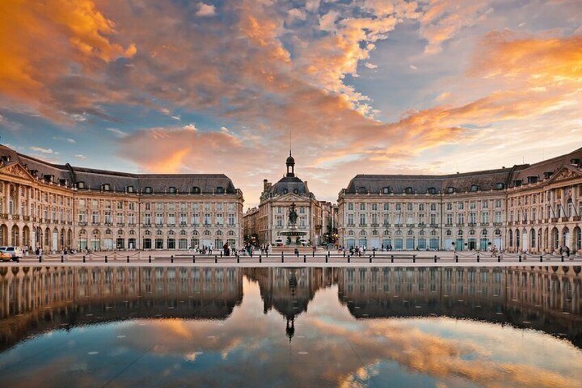 Un imponente edificio con una cupola, circondato da uno specchio d'acqua, sotto un cielo tempestoso. 2
