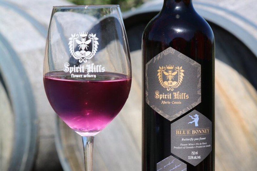 Una copa de vino y una botella de vino Spirit Hills Blue Bonney. 5