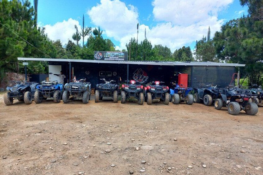 En række ATV'er parkeret foran en bygning med et skilt, der siger 'ATV Rental'. 2