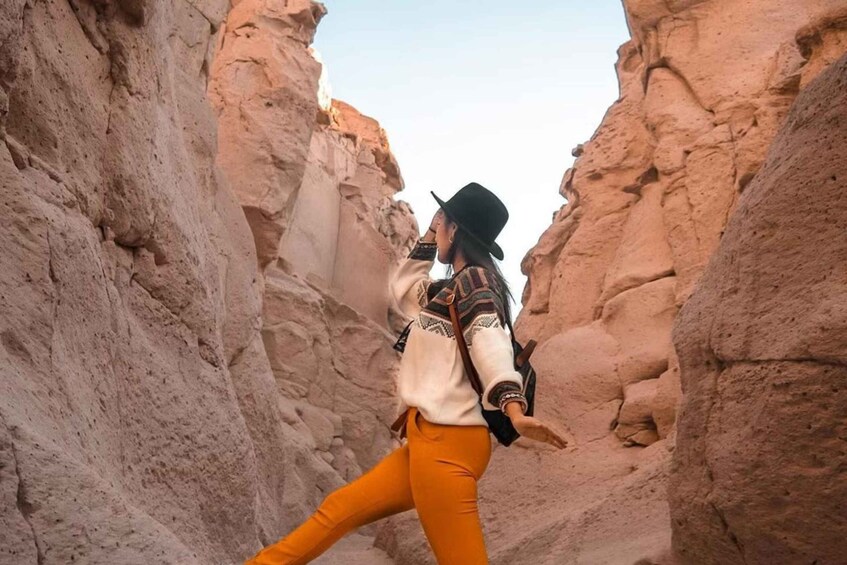A person walking through a narrow canyon with rocky walls. 1