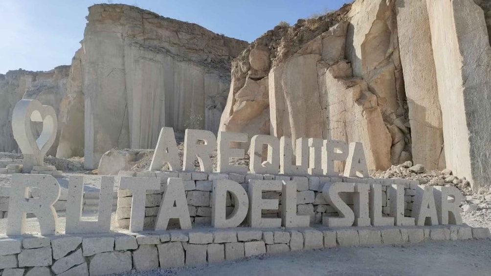 A large rock formation with the text 'ARQUITA FRUTA DEL SILLAR' carved into it. 3