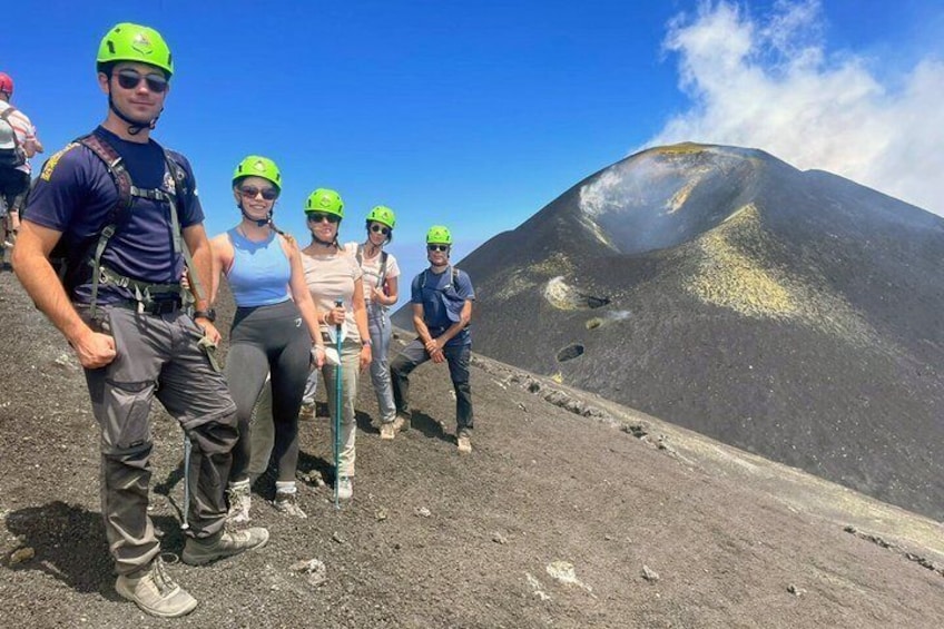 A group of people wearing helmets and hiking gear on a volcanic landscape. 5