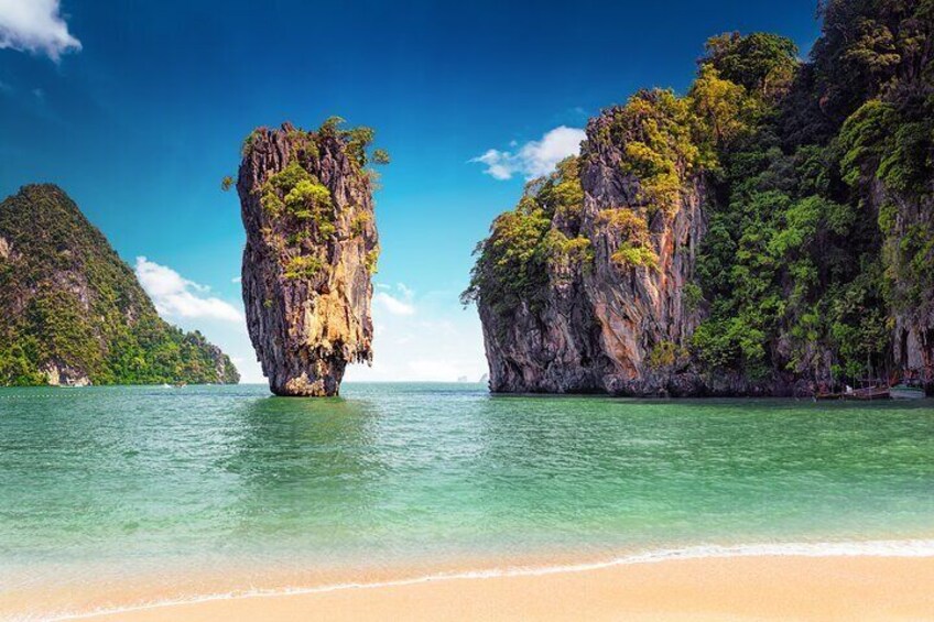 Une plage bordée d’une eau turquoise et limpide, une imposante île calcaire et de luxuriantes falaises verdoyantes. 4