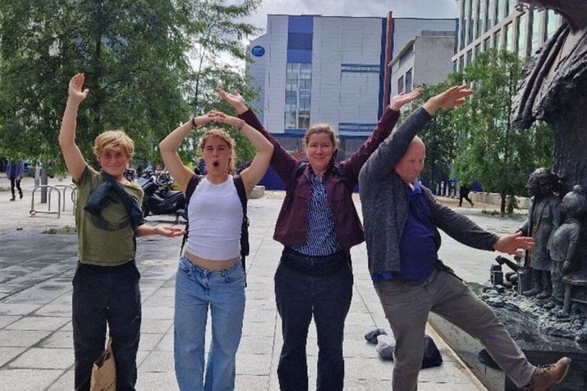 A group of people posing in front of a sculpture. 5
