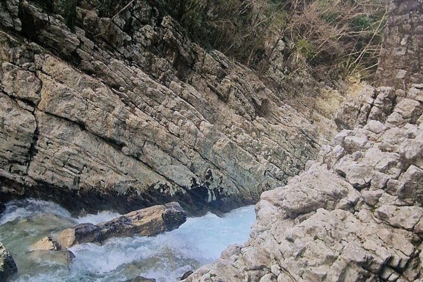 A rocky riverbed with water flowing through it. 5