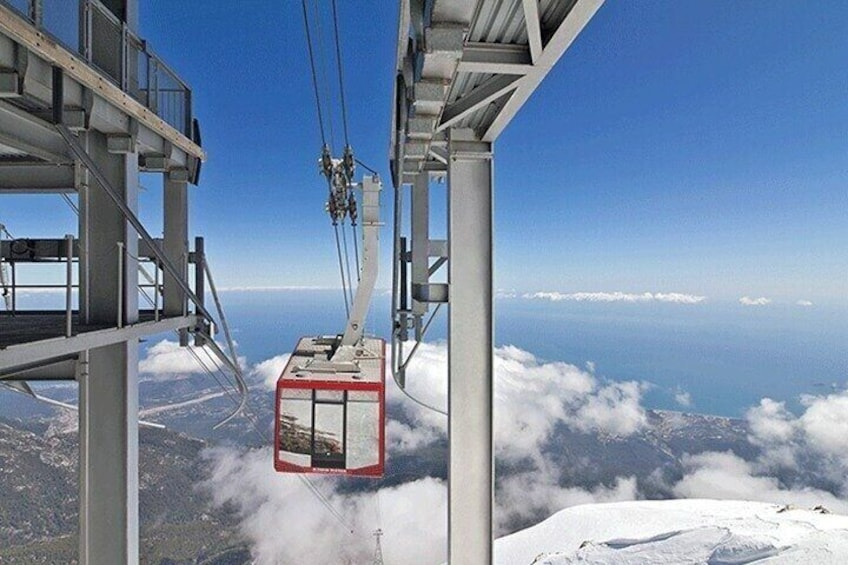 A cable car suspended above a snowy landscape with a clear sky. 2
