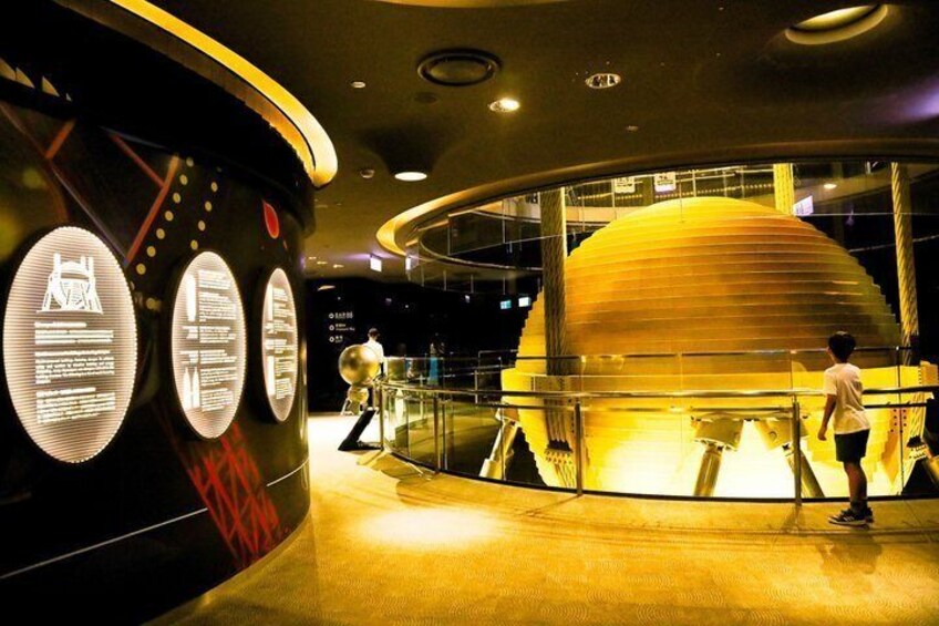 A modern building with circular informational displays and a large spherical structure. 5