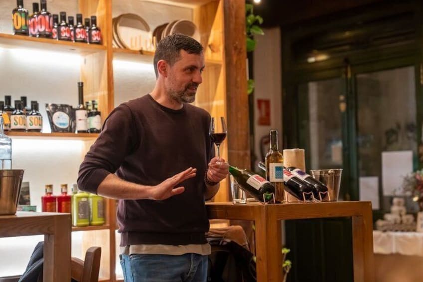 A person holding a wine glass in a bar with shelves of bottles and glasses. 2