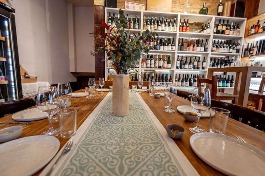 A restaurant table set with plates, glasses, and a vase with flowers. 3